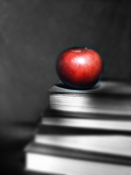 Red apple on top of black and white books